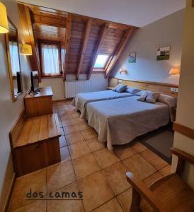 1 dormitorio con 2 camas y techo de madera en Hostal y Apartamento Seixes, en Bagergue