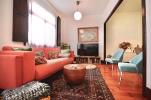 - un salon avec un canapé rouge et une télévision dans l'établissement Precioso Piso en el Centro de Vigo, à Vigo
