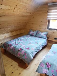 1 dormitorio con 1 cama en una cabaña de madera en Vila Planinski san 1, en Zaovine