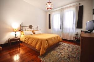 - une chambre avec un lit et une télévision dans l'établissement Precioso Piso en el Centro de Vigo, à Vigo