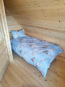 a bed in a room with a wooden wall at Vila Planinski san 1 in Zaovine