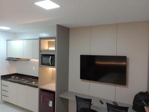 a kitchen with white cabinets and a black counter top at Laguna Beach House in Cabedelo