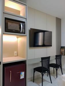 a room with a table and two chairs and a microwave at Laguna Beach House in Cabedelo