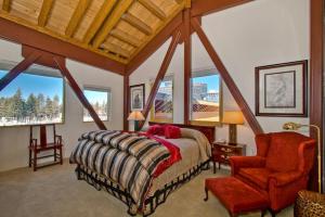 a bedroom with a bed and a chair and windows at Downtown Penthouse in South Lake Tahoe