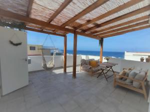 een patio met stoelen en een tafel op een dak bij Nueve Pies Surf house in Las Palmas de Gran Canaria