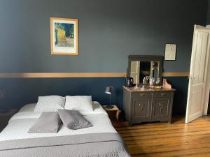 ein Schlafzimmer mit einem Bett und eine Kommode mit einem Spiegel in der Unterkunft Vakantielogies Faja lobi in Gent