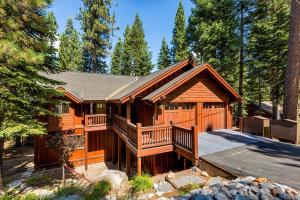 a large wooden cabin with a deck in the woods at Forest View Lodge in South Lake Tahoe