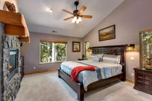 a bedroom with a bed with a ceiling fan and a fireplace at Forest View Lodge in South Lake Tahoe