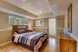 a bedroom with a bed and a table and two windows at Sequoia Chalet in Stateline