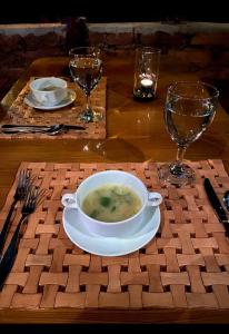 a bowl of soup sitting on a table with glasses at Green View Safari Paradise in Udawalawe