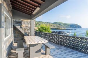 a bench on a balcony with a view of the ocean at Mosteiros Natural Pool House in Mosteiros
