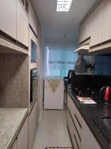 una cucina con frigorifero bianco e piano cottura di Cleverson Machado a Itapema