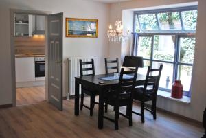 a kitchen and dining room with a table and chairs at Ferienwohnungen Meerwiefke in Leer