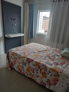 una camera da letto con un letto con una coperta a fiori di Cleverson Machado a Itapema