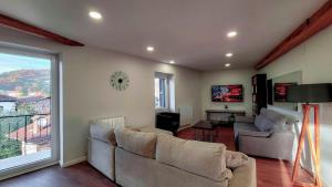 a living room with two couches and a large window at Apartamentos Elizondo Center in Elizondo