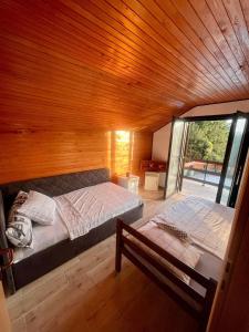 een slaapkamer met 2 bedden en een houten plafond bij DOLINA SUNCA (Ranch Corral) in Popovača