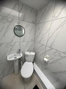 uma casa de banho branca com um WC e um lavatório em Experience Downing Road Dagenham 2 bedroom Apartment em Dagenham