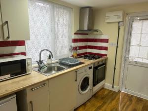 uma cozinha com uma máquina de lavar roupa e um lavatório em Experience Downing Road Dagenham 2 bedroom Apartment em Dagenham