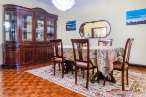 uma sala de jantar com uma mesa com cadeiras e um espelho em Pinheiro SUN&BEACH House em Ponta Delgada