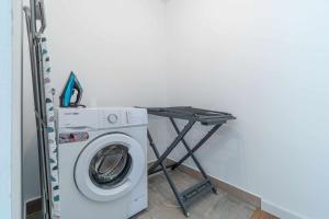 a washing machine and a table in a room at Jouvacations Villa La Selva in Vilafant