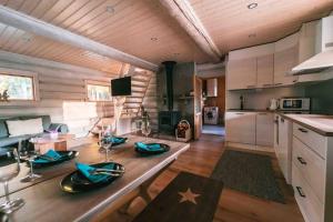 een keuken en een woonkamer met een houten plafond bij Upea hirsi mökki ulkoporeltaalla in Hämeenlinna