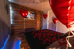 una habitación con corazones rojos en una cama con globos en Upea hirsi mökki ulkoporeltaalla, en Hämeenlinna