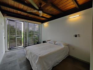 a bedroom with a bed and a large window at Casa Ilhe Ha in Santa María Tonameca +56 photos