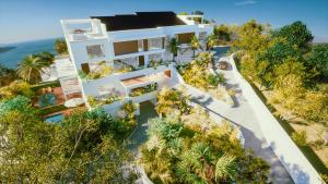 an aerial view of a white house with palm trees at Aura Anse Marcel in Anse Marcel 