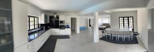 a large white kitchen with a table and chairs at LouriVillage in Lourinhã