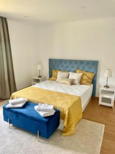 a bedroom with a large bed with a blue headboard at LouriVillage in Lourinhã +25 photos