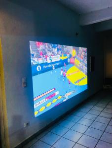 una pantalla grande con un juego de baloncesto en la pared en Habitation SANTOS 4 personnes Terre de Haut Les Saintes, en Terre-de-Haut