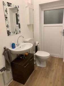 a bathroom with a white toilet and a sink at Residence Anke 