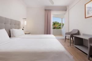 una camera d'albergo con letto, scrivania e finestra di Nafsika Hotel - Adults Only a Dassia