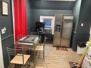 uma cozinha com um frigorífico, uma mesa e cadeiras em Fashionably cozy2 em Meriden