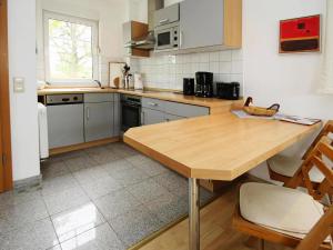 a kitchen with a wooden table and a counter top at Cottage on the Kummerower See, Kummerow in Kummerow