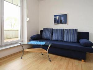 a living room with a blue couch and a glass table at Cottage on the Kummerower See, Kummerow in Kummerow