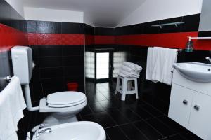 een zwart-rode badkamer met een toilet en een wastafel bij HOTEL POSIDONIA INN SAPRI in Sapri