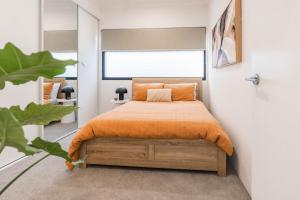 una camera con un letto e una coperta arancione di Beautiful 4BR Family home with Patio and Parking! a Perth