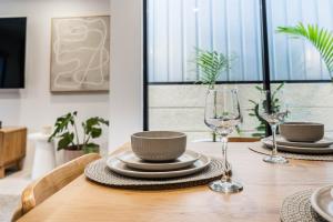 un tavolo di legno con piatti e bicchieri di Beautiful 4BR Family home with Patio and Parking! a Perth