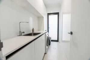 una cucina bianca con lavandino e doccia di Beautiful 4BR Family home with Patio and Parking! a Perth