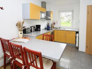 een keuken met een witte tafel en een aantal stoelen bij Cottage on the Kummerower See, Kummerow in Kummerow