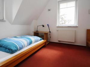 a bedroom with a bed with a lamp and a window at Cottage on the Kummerower See, Kummerow in Kummerow