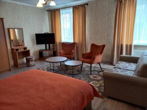 a living room with a couch and chairs and a television at Daugavpils City Centеr Apartment in Daugavpils