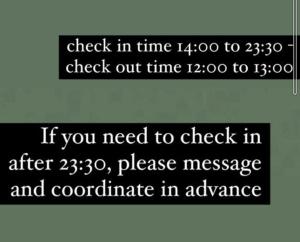 ドバイにあるBackpackers Hostelのチェックイン時刻からチェックアウト時刻を表示する看板