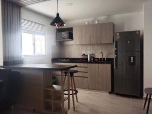 a kitchen with a black refrigerator and a table at Acogedor apartamento con sala de TV in Sabaneta