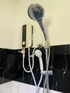 a shower head and a hair dryer in a bathroom at Chill House safari resort in Udawalawe