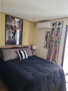 um quarto com uma cama e algumas fotografias na parede em Apartamento/ flat em São Vicente em São Vicente