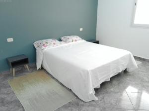 una camera da letto con un grande letto bianco con lenzuola bianche di Villa Belle-Vue a Tabarka