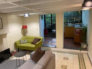 a living room with a couch and a green chair at B&B Faja lobi in Ghent