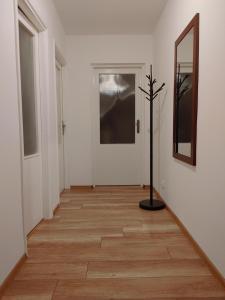 a hallway with white walls and a mirror and a wooden floor at Grudziądzka 69 Apartment in Wrocław